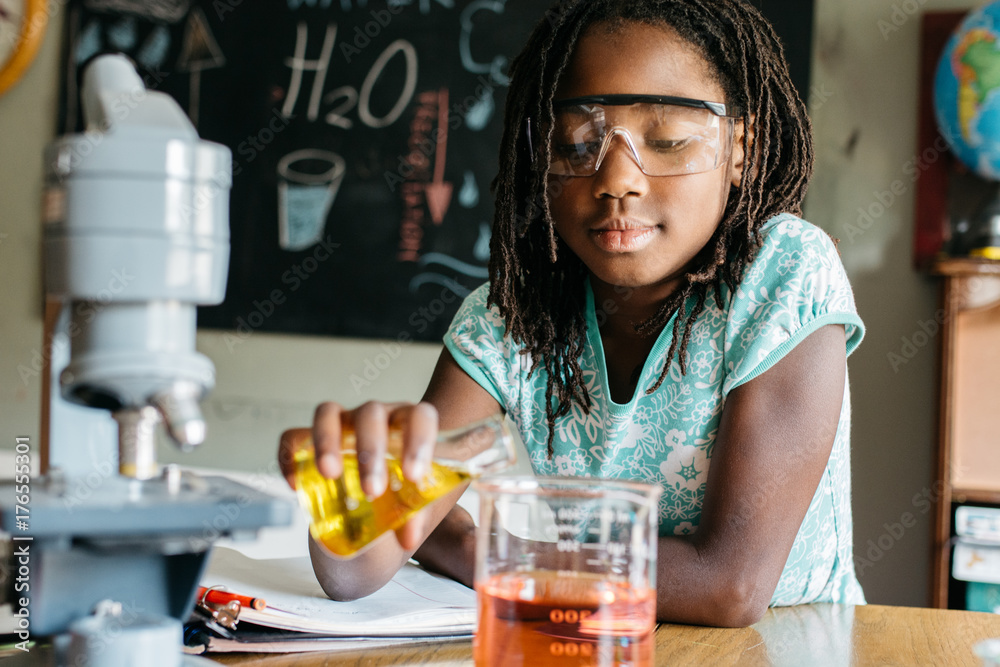 Girl doing a chemistry experiment in science class Girl doing a chemistry experiment in science class