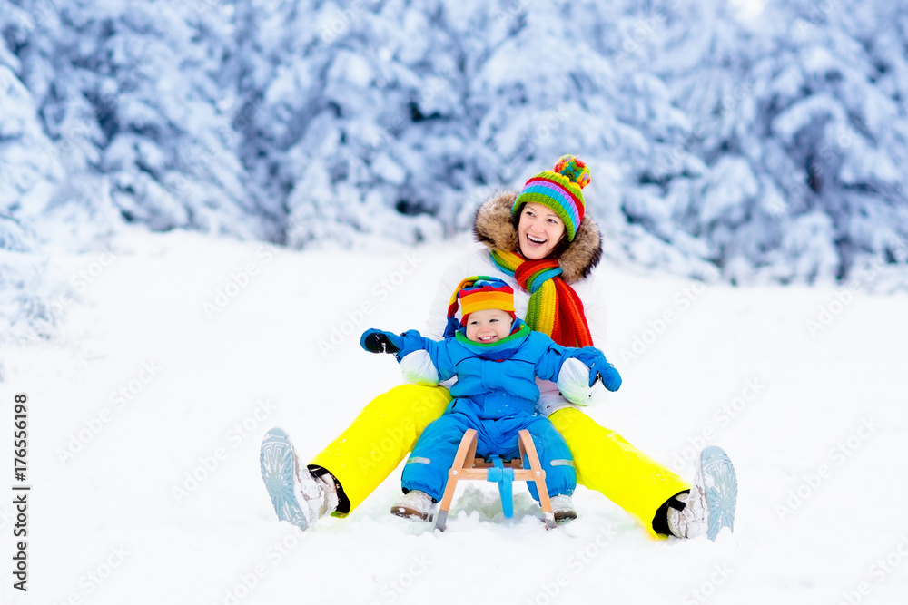 Mother and baby on sleigh ride. Winter snow fun. Mother and baby on sleigh ride. Winter snow fun.