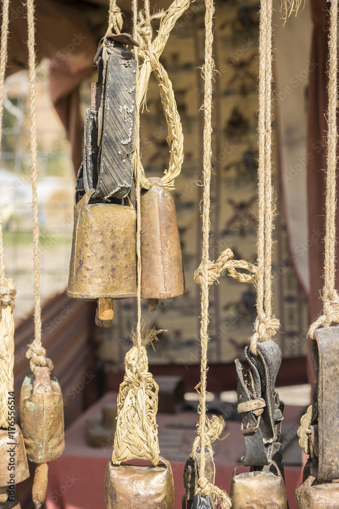 metal and brass cowbells hanging in a medieval stall