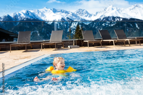 Child in outdoor swimming pool of alpine resort © famveldman