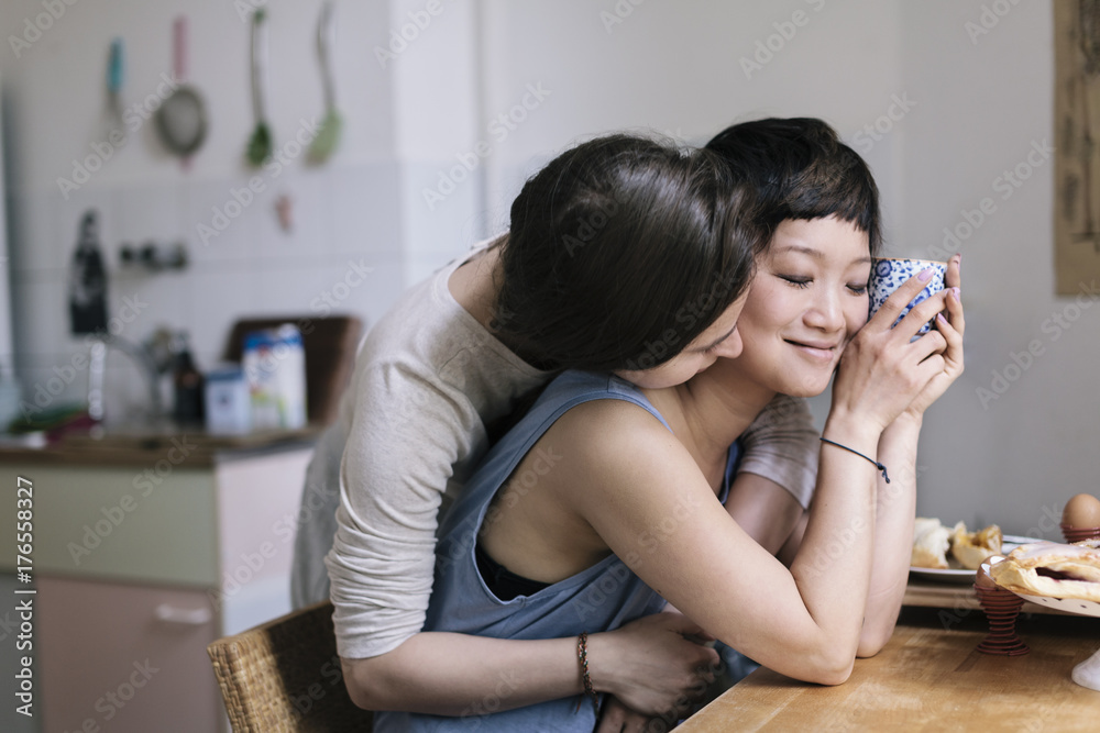 Affectionate homosexual females embracing at table Affectionate homosexual females embracing at table