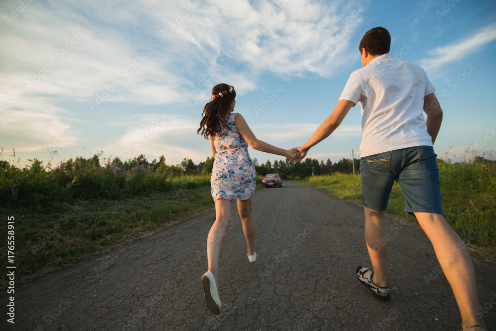 Young couple running along country road.