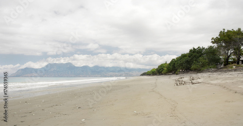 Empty white sand beach with pebbles and clear blue ocean waves at Bajawa Ruting Flores in the morning.