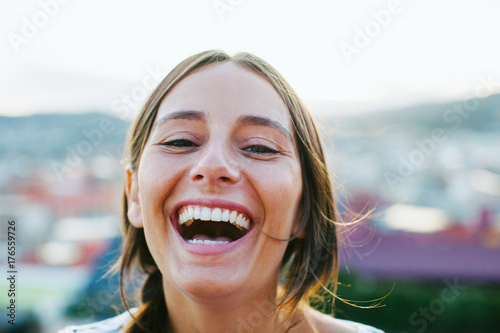 Portrait of a young woman laughing outside. photo