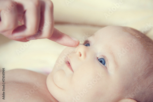 mother touches the nose of the child with a finger