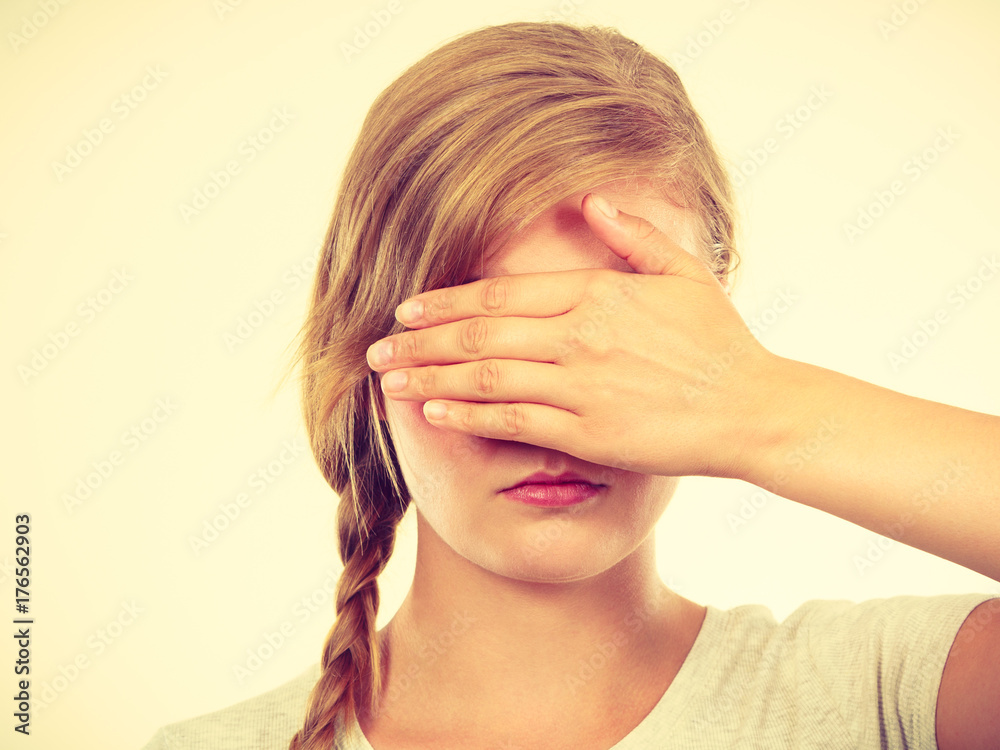 Shy teenage girl hiding face behind hand Shy teenage girl hiding face behind hand