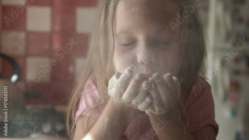 Young girl playing with flour in kitchen while preparing dough