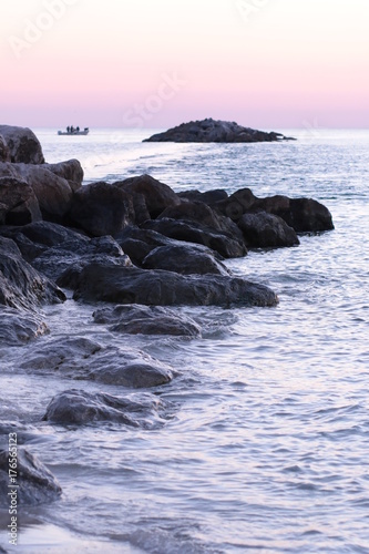 rock barrier in the ocean at dusk
