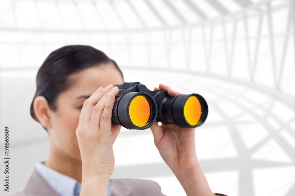 Composite image of brunette businesswoman looking through