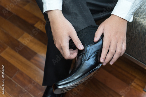 Man wears leather shoes in morning wedding preparations or business work