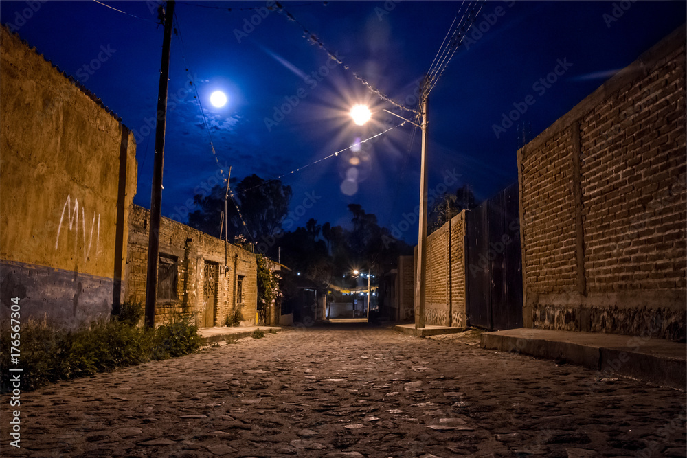 Scary night shot in empty rural town with full moon and clear sky