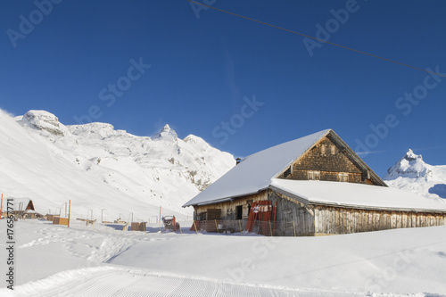 TIMBER FARMER BARN HOUSE IN WINTER MOUNTAIN SNOW COVERED LANDSCAPE IN MELCHSEE FRUTT, SWITZERLAND © designagy