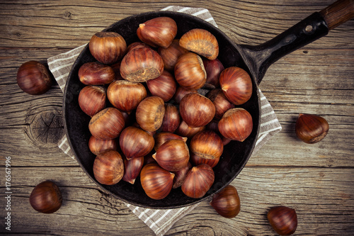 chestnuts in a pan on a wooden background
