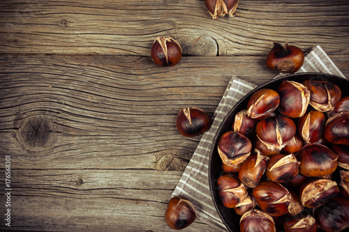 chestnuts in a pan on a wooden background photo