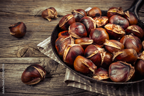 chestnuts in a pan on a wooden background