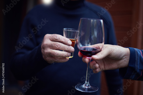 Hands holding glasses and toasting, happy festive moment, luxury celebration concept. People, men, leisure, friendship and celebration concept - happy male friends drinking and clinking glasses.