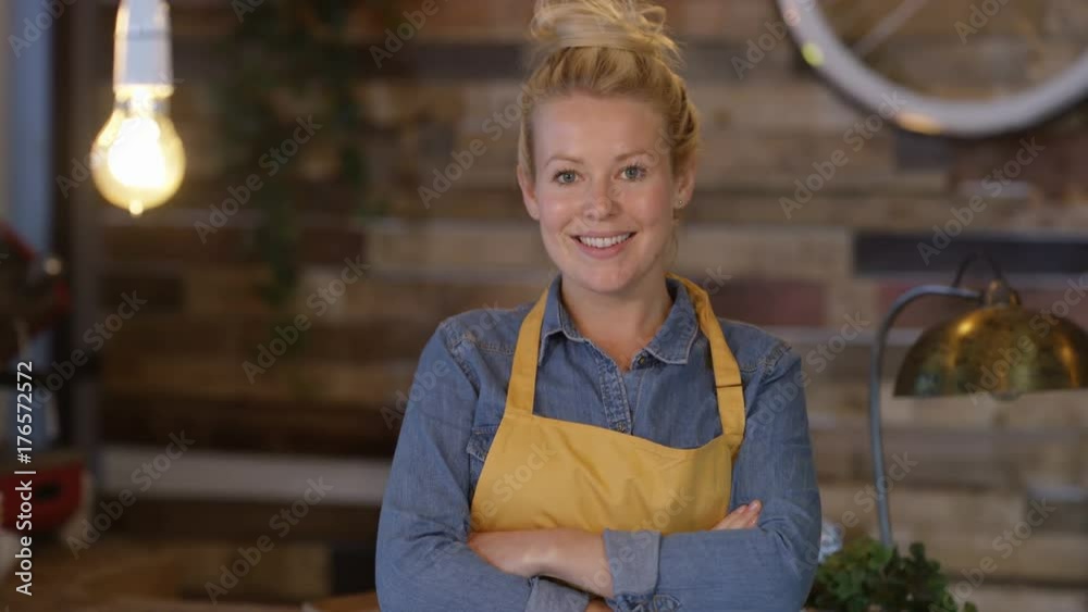 Portrait smiling barista or business owner behind the counter in cafe