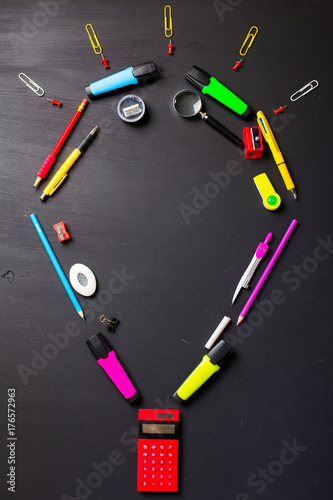 School supplies on black background. Flat layout.