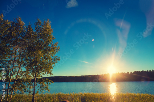 Lakeshore with trees at sunset. Beautiful nature Finland