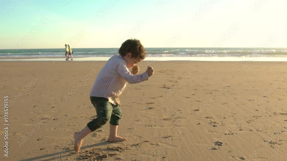 Slow video of Happy kid running and playing on the beach Slow video of Happy kid running and playing on the beach