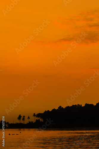 After sunset orange glow over the sun and sea  with silhouette of an island behind