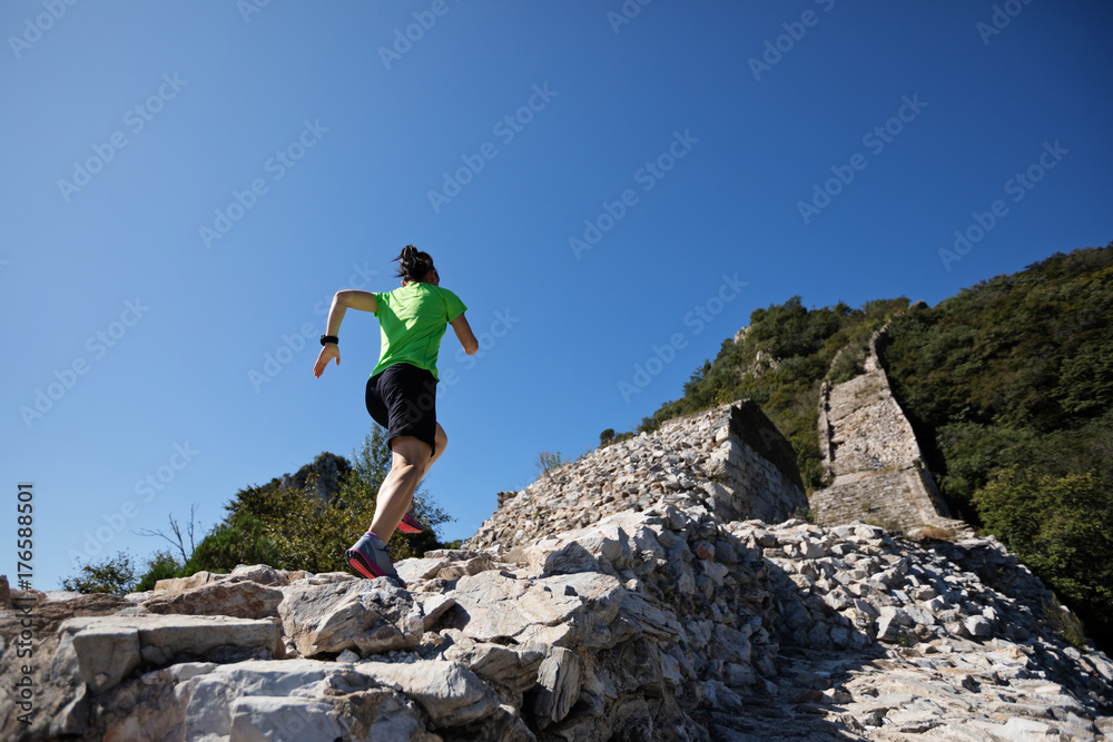 woman trail runner running at mountain top