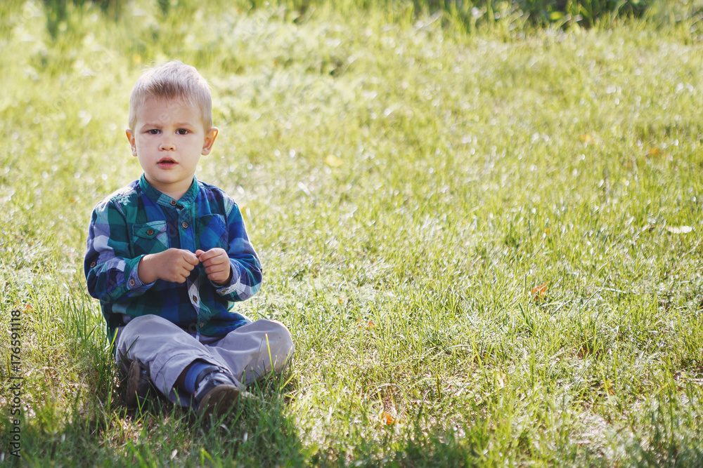 Little boy having fun playing in the Park on the grass Little boy having fun playing in the Park on the grass