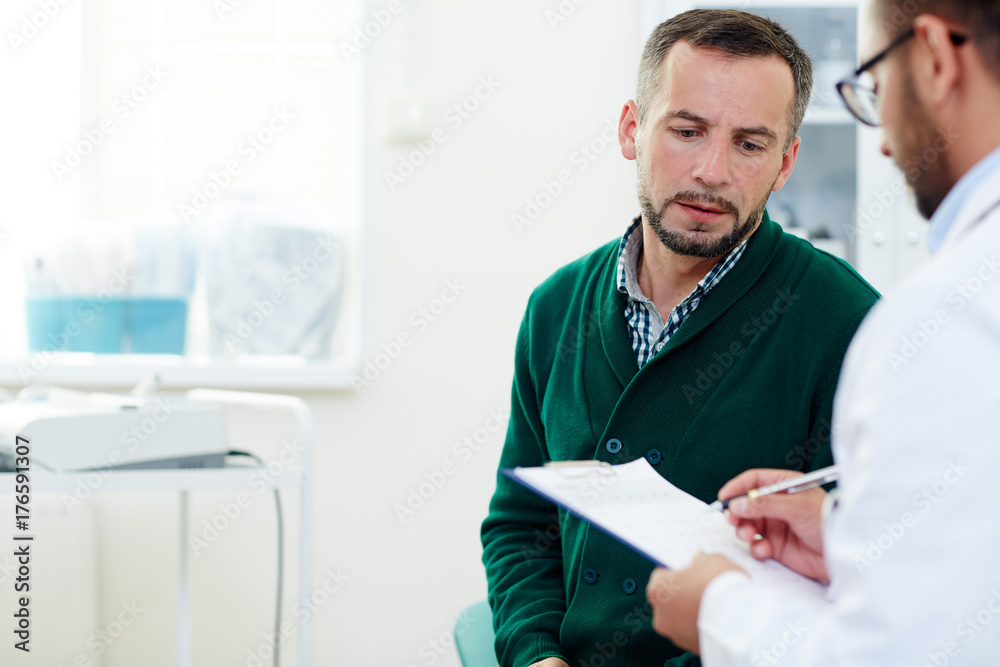 Obraz premium Anxious patient listening to his doctor in hospital after examination