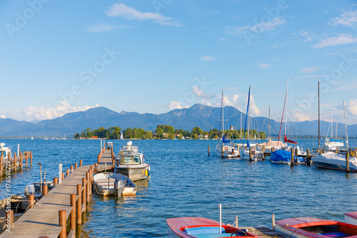 Boats at jetty at Seebruck with Fraueninsel at Lake Chiemsee, Bavaria on a sunny summer day photo