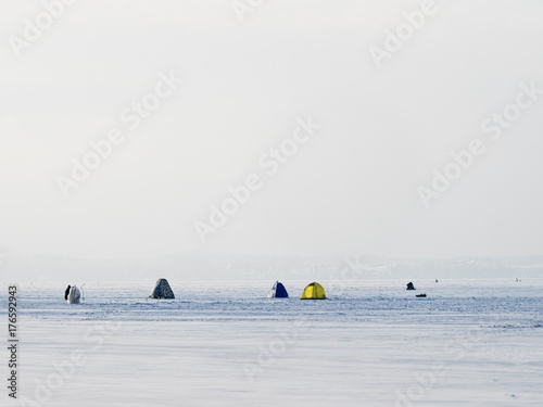 Ice anglers on the lake ice in the cold winter day