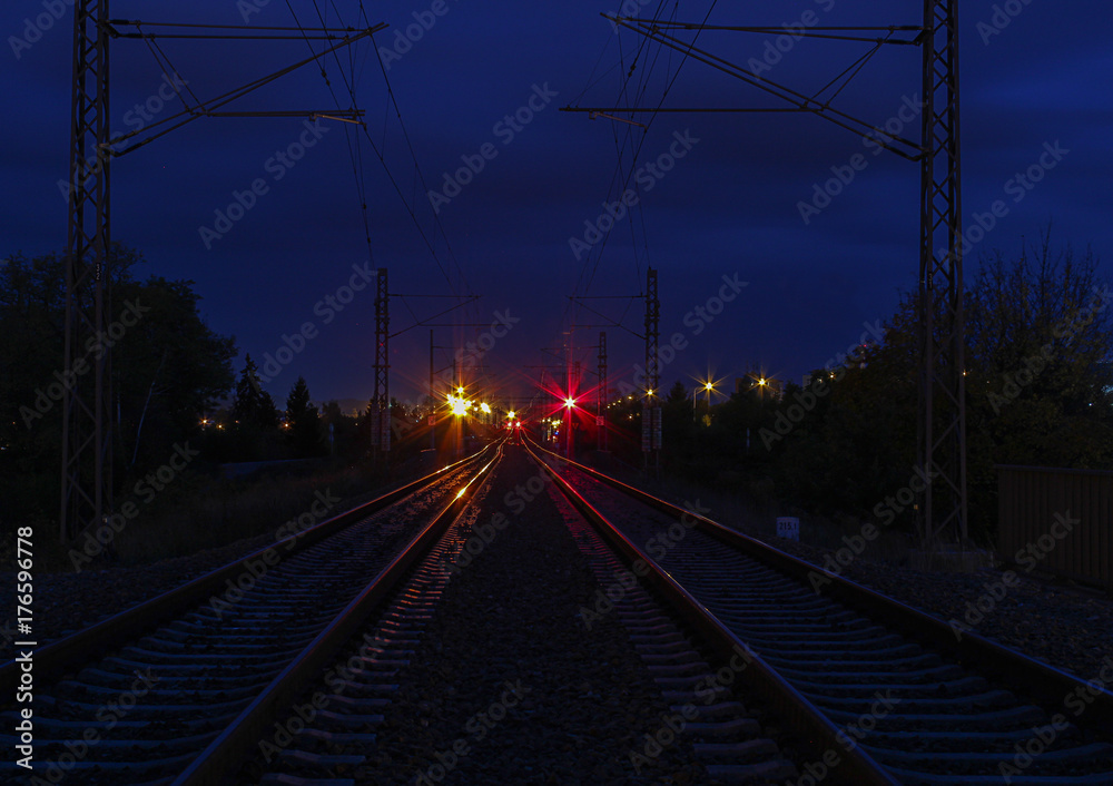 Railway track in night with red and orange light