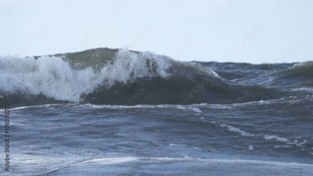 Stormy seas during bad weather cyclone hurricane Winds. Slow motion sea ocean water big surf wave splash beach.