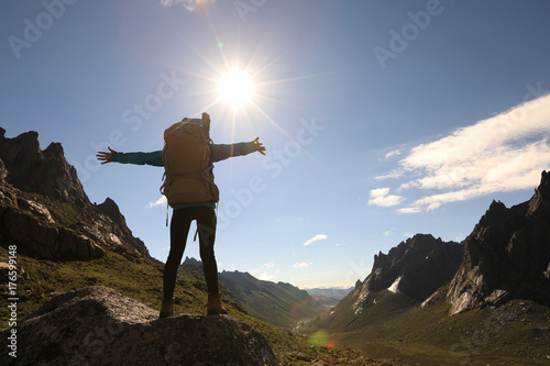 cheering successful woman hiker on mountain top