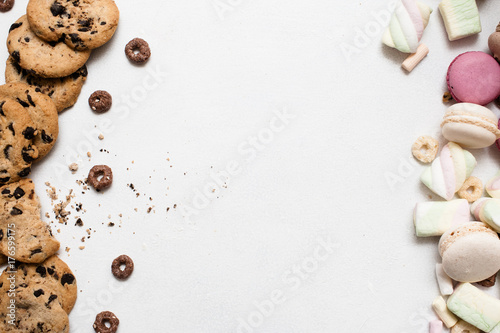 Sweet colorful background with free space. Wholegrain chocolate scone, macaroons and marshmallow top view, culinary art of homemade pastry, sweet bakery concept photo