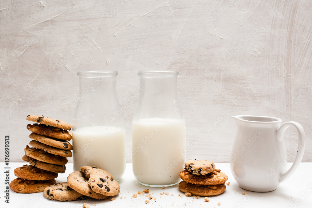 Wholegrain products eating with milk, close up. Chocolate scones in one line with bottles and pitcher of lacto drink. Home-baked shop concept Wholegrain products eating with milk, close up. Chocolate scones in one line with bottles and pitcher of lacto drink. Home-baked shop concept