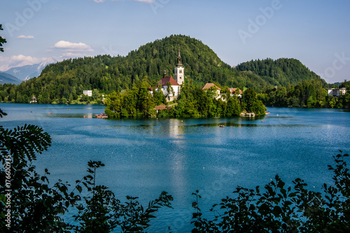 Landscape view of the blue lake Bledsko jezero and island with sanctuary in the center of the photo.Summer in Julian Alps, Bohinj, Slovenia, Europe.