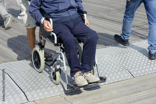 Man using wheelchair on street photo