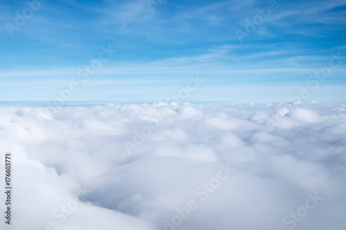 Clouds in blue sky  aerial view from airplane window.