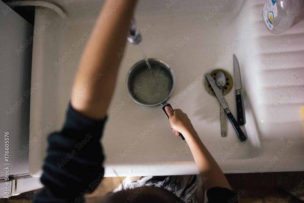 Vaisselle dans l'évier avec main et casserole Stock Photo | Adobe Stock