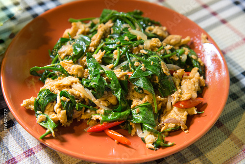 Liang vegetable fried with eggs delicious Thai local food, there are green leaves fried with eggs on orange plate
