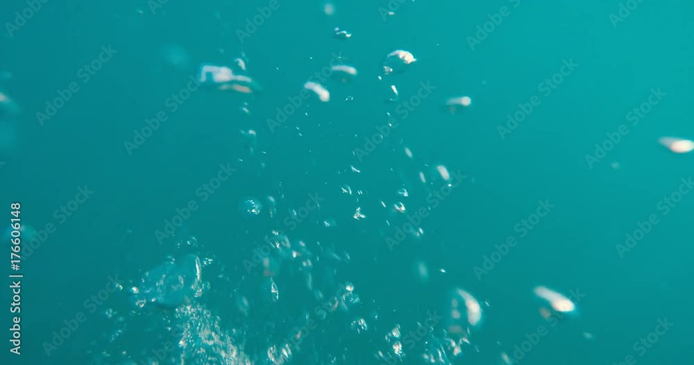 the hands of a floating man under the water