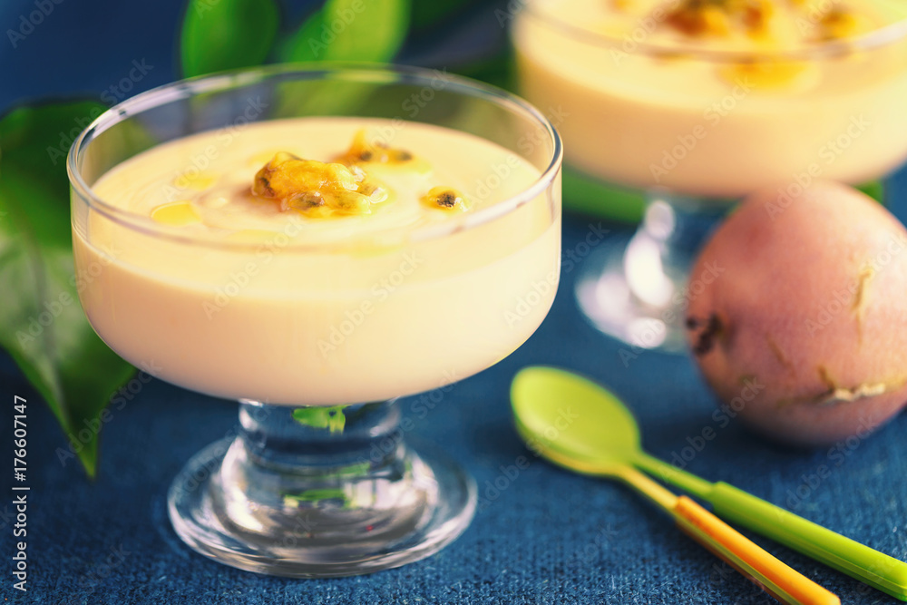 Passion fruit mousse in glass ramekin on dark blue background Passion fruit mousse in glass ramekin on dark blue background