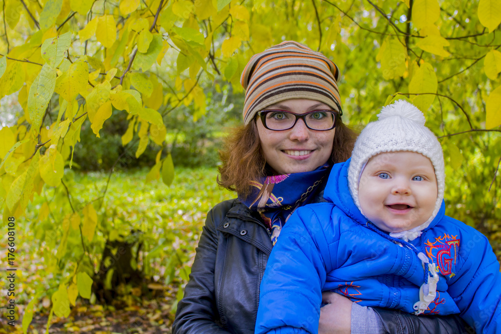 Happy mother and son are walking in the autumn park Happy mother and son are walking in the autumn park