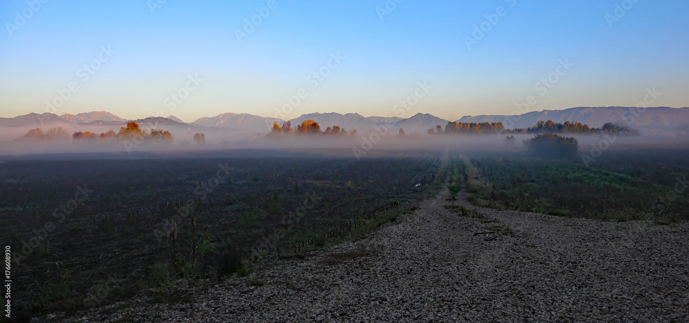 fog in the fields on a cold autumn day and mountains in the back fog in the fields on a cold autumn day and mountains in the back