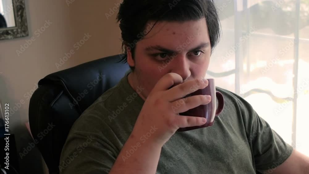slow boy drinks coffee and grins