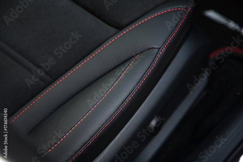 Red stitching on black leather car seat
