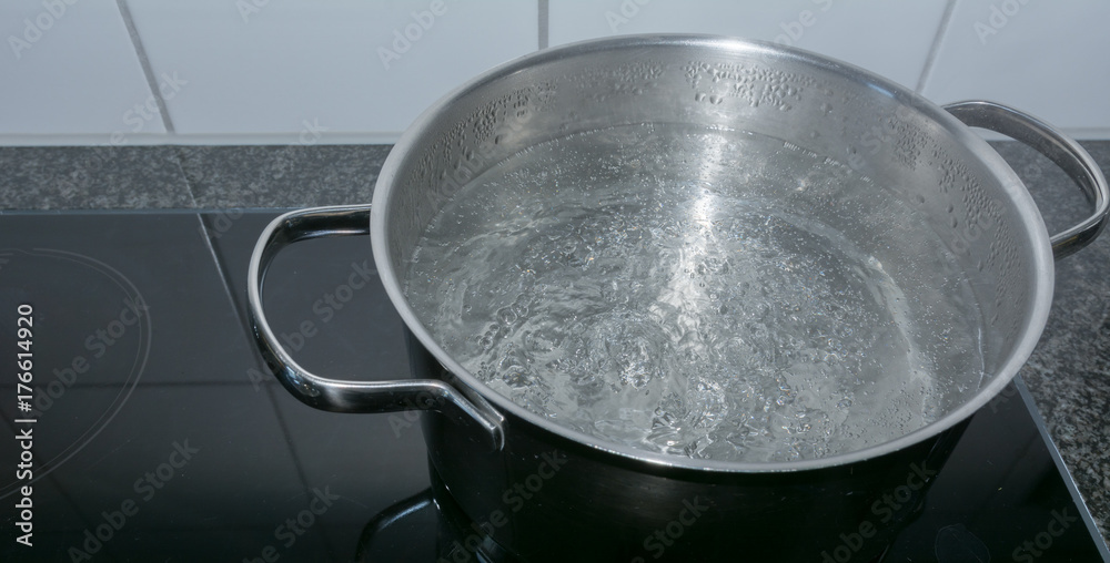 Kochendes Wasser in der Pfanne auf dem Herd in der Küche Kochendes Wasser in der Pfanne auf dem Herd in der Küche