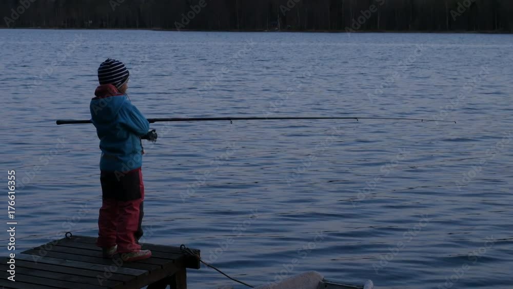 Child fishing at dusk, little girl with rod fishing Child fishing at dusk, little girl with rod fishing