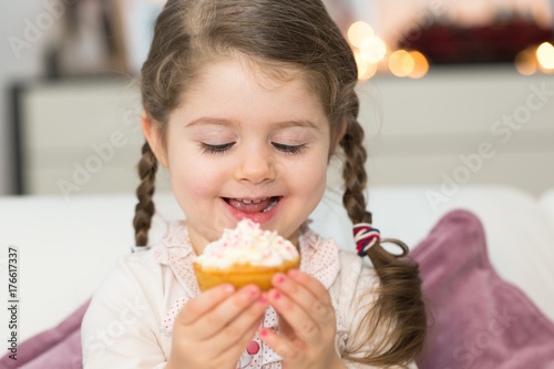 Foto Cute girl eating muffin