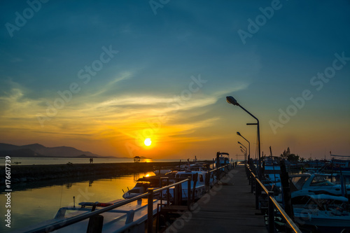 Brown Wooden bridge pier with  a lot of boat in sunset. Koh Samui  ,Thailand.